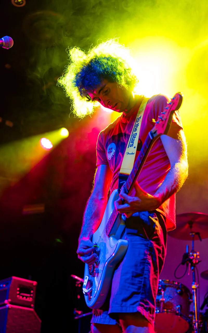guitar player on stage with colorful backlighting photograph